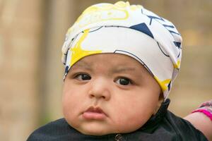 Close Up Shot of Cute Asian Pakistani 4 Months Old Baby Boy, Who is Enjoying at Home Garden at Luton City of England UK. Image Was Captured on July 23rd, 2023 photo