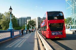 Gorgeous Low Angle view of Bus Service and British Traffic at London Bridge Which is Most Famous and Historical Bridge over River Thames at Central London City of England UK. June 4th, 2023 photo