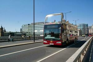 Gorgeous Low Angle view of Bus Service and British Traffic at London Bridge Which is Most Famous and Historical Bridge over River Thames at Central London City of England UK. June 4th, 2023 photo