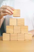 hand placing or pulling wooden block on the building. Business planning, Risk Management, Solution and strategy Concepts photo