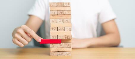 hand pulling wooden block tower on table. Business planning, Risk Management, Solution, leader, strategy, Crisis, falling Business, and Economic recession concept photo