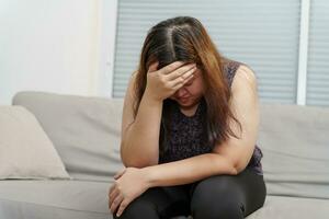 triste exceso de peso más Talla mujer pensando acerca de problemas en sofá trastornado niña sensación solitario y triste desde malo relación o Deprimido mujer trastorno mental salud foto