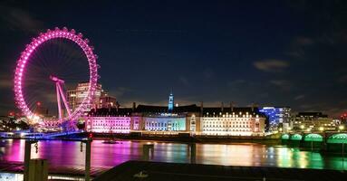 Most Beautiful Footage of Illuminated London eye from River Thames Westminster, Big Ben clock Tower at After Sunset Night. England Great Britain,  Footage Was Captured on Aug 02nd, 2023 After Sunset. photo