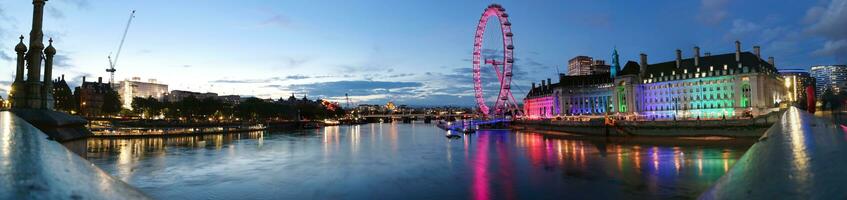 más hermosa imágenes de iluminado Londres ojo desde río Támesis Westminster, grande ben reloj torre a después puesta de sol noche. Inglaterra genial Bretaña, imágenes estaba capturado en ago 02, 2023 después puesta de sol. foto