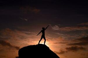 Goddess on a Rock at Sunrise Silhouetted by Sky photo