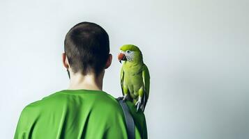 Beautiful green Monk parrot sitting on shoulder of man. photo