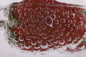 red juicy ripe fresh strawberry in sparkling water in close-up photo