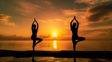 Two women doing yoga at sunrise. silhouette concept photo