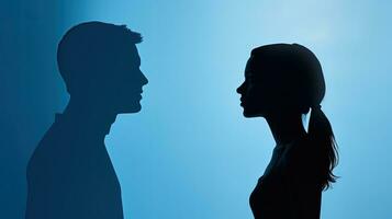 Flat lay of a white paper silhouette of a couple on a blue background with space for text photo