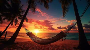 maravilloso puesta de sol terminado un tropical playa con palma arboles y un hamaca. silueta concepto foto
