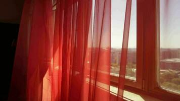 a window with a red curtain and a view of the city video