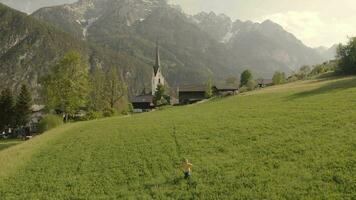 ein Junge ist Gehen durch ein Feld mit Berge im das Hintergrund video