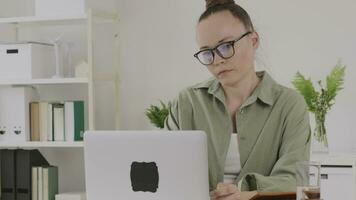 ein Frau im Brille ist Arbeiten auf ihr Laptop video