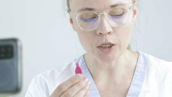 un logopedista en un blanco laboratorio Saco es enseñando cómo a hacer habla terapia video