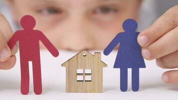 a person holding a paper cutout of a family with a house video