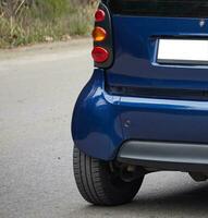 Little blue car driving on the road,  modern city car background photo