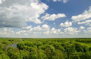 Peaceful atmosphere of white clouds, river and green forest photo