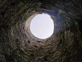 Stone well hole, old construction from inside, fall down in the well photo