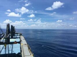 View from the bridge of the handymax bulk carrier to the holds and the ocean during the day. Large cargo ship in the ocean photo