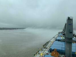 View from the bridge of the handymax bulk carrier to the hold. Large cargo ship in the river. Fog begins to fall on the river photo