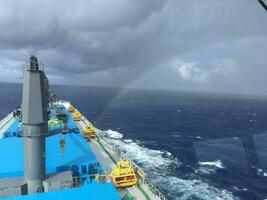 View from the bridge of the handymax bulk carrier to the holds and the rainbow during the day. Large cargo ship in the ocean photo