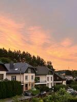 puesta de sol en el pueblo con vista a el europeo casas y el bosque. moderno privado casas vivo en el medio de naturaleza foto