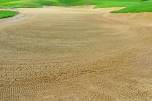 golf curso arena pozo búnkeres, verde césped rodeando el hermosa arena agujeros es uno de el más desafiante obstáculos para golfistas y agrega a el belleza de el golf curso. foto