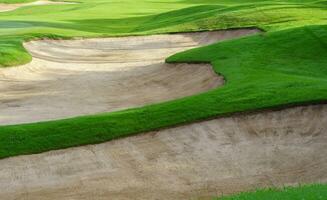 golf curso arena pozo búnkeres, verde césped rodeando el hermosa arena agujeros es uno de el más desafiante obstáculos para golfistas y agrega a el belleza de el golf curso. foto