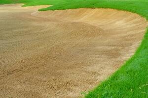 Golf Course Sand Pit Bunkers, green grass surrounding the beautiful sand holes is one of the most challenging obstacles for golfers and adds to the beauty of the golf course. photo