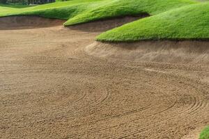 Golf Course Sand Pit Bunkers, green grass surrounding the beautiful sand holes is one of the most challenging obstacles for golfers and adds to the beauty of the golf course. photo