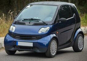 Little blue car driving on the road,  modern city car background photo