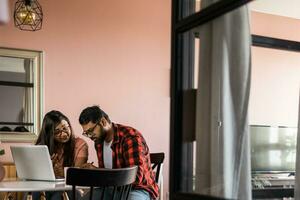 milenario indio marido y esposa haciendo Doméstico papeleo, contabilidad trabajo y revisando papel facturas, ingresos a ordenador portátil computadora, utilizando en línea calculadora - económico crisis concepto foto