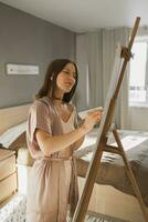 Pretty talented woman painter painting on easel making colorful sketches creating wonderful art. Beautiful female artist painting with pastel. Creativity and imagination concept photo