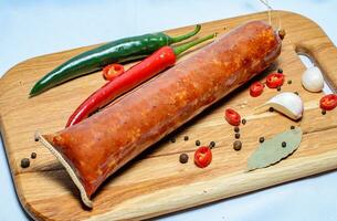 Tasty sausages and vegetables isolated over solid background photo