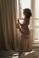 joven mujer disfrutando soleado Mañana en dormitorio - despierta y bienestar concepto foto