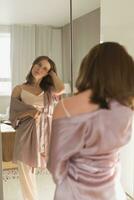 Happy morning. Attractive young woman looking in mirror at her apartment - wake up and new day photo