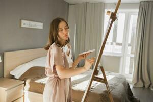 Pretty talented woman painter painting on easel making colorful sketches creating wonderful art. Beautiful female artist painting with pastel. Creativity and imagination concept photo