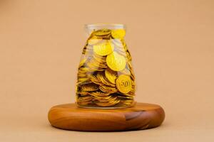 Saving gold in a glass jar Real estate and valuables Gold coins World gold market Gold stocks Invest in gold photo