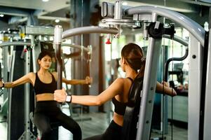 Exercise your arms with this arm exercise machine. healthy women exercise in fitness gym photo