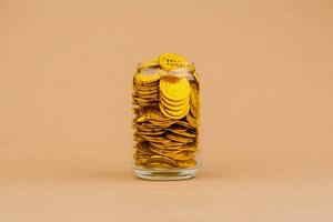 gold in glass jar gold savings in glass jar valuable assets Financial loans and investments. Gold stocks. Gold market. Gold concept and gold accumulation. photo