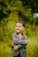 cute little boy A well-dressed boy in a suit in a backyard with a lawn and looking for something interesting. photo