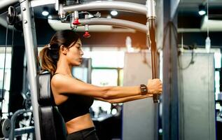 Exercise your arms with this arm exercise machine. healthy women exercise in fitness gym photo