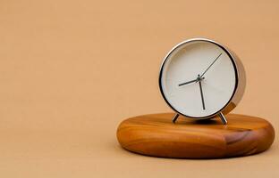 alarma reloj metido en un de madera pararse, hora trabajo concepto el valor de limitado hora equipo y puntualidad a trabajo foto