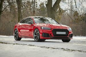 Modern red car in the winter forest background,  car wallpaper photo