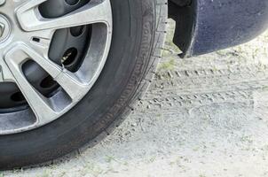 Car wheel and its prints on the ground photo