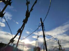 Barbed twisted wire metal fence close view photo