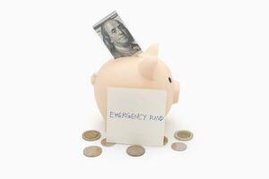 concept of emergency savings fund. A piggy bank with dollar and coins. piggy bank for saving emergency money.Saving for emergency concept. isolated background. photo