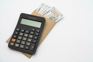 Dollars in paper envelopes with Calculator isolated on white background. Finance and profits concept. photo