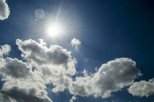 Blue sky with white clouds in sun rays photo