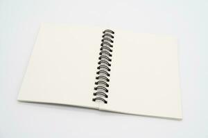 realista abrió cuaderno con bolígrafo. vertical blanco libro de copiar con metálico negro espiral. bloc untado para tu diseño. realista libro de copiar con oscuridad aislado antecedentes. foto